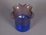 a glass vase with a blue base on a table