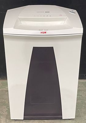 the paper shredder is sitting on the floor in front of a black wall