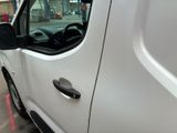a white van parked in a parking lot with its door open
