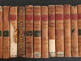Plusieurs vieux livres sont alignés sur une surface noire