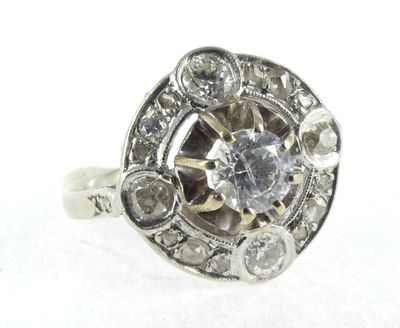 an image of a diamond ring with a center stone surrounded by diamonds