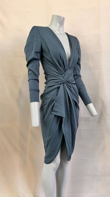 the mannequin is wearing a gray dress with long sleeves
