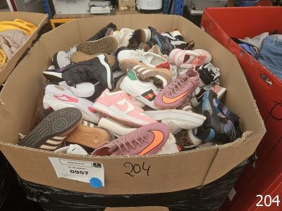 plusieurs paires de chaussures dans une boîte posée sur le sol