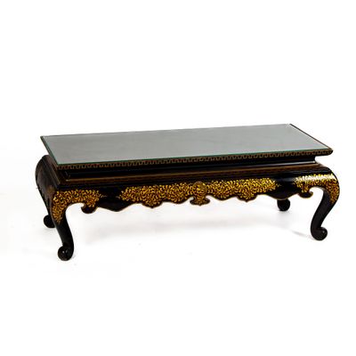 une table basse noire et dorée avec un plateau en verre