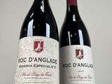 two bottles of red wine sitting next to each other on a table