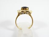a close up of a gold ring with a black stone