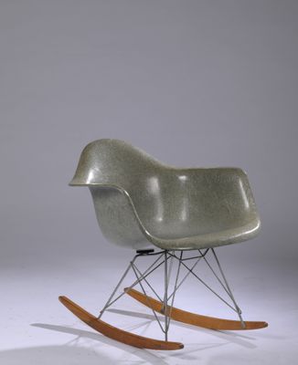 un fauteuil à bascule avec une assise en bois et un piètement en métal