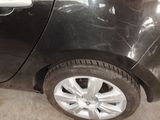 a black car that has a broken tire on the side of the road