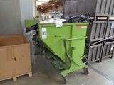 a green dumpster sitting next to a brown box in a warehouse