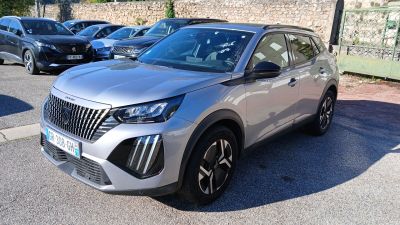 Le SUV argenté est garé sur le parking, à côté d'autres voitures.