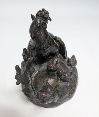 a statue of a rooster sitting on top of a rock
