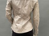 the back of a mannequin wearing a beige jacket and black pants