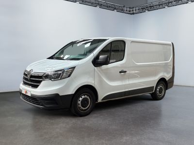 La camionnette blanche est garée dans une grande pièce aux murs blancs.