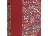 un vieux livre à la couverture rouge ornée d'un motif en spirale