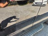 a reflection of a person taking a picture of a car in a mirror