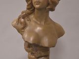 bronze bust of a woman with wavy hair on a marble base