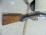 an old rifle laying on the ground next to a bag