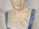 une statue représentant une femme en robe bleue posée sur une table