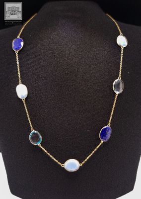un collier en or orné de perles de verre bleues et blanches, présenté sur un mannequin