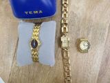 a watch and a bracelet on a table next to a blue purse