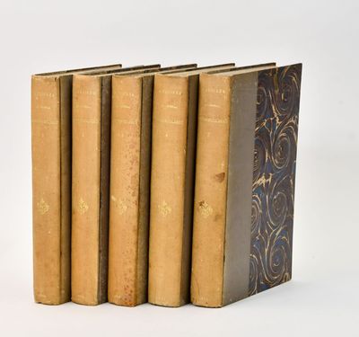 five old books are stacked on top of each other on a white surface