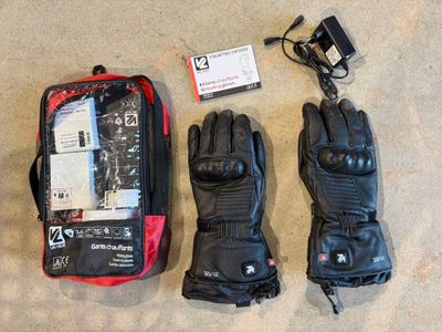 une paire de gants et un sac de voyage posés par terre