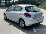 a silver car parked in a parking lot with trees in the background