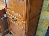 a wooden cabinet that has a drawer on top of it