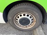 a close up of a tire on a green and white bus