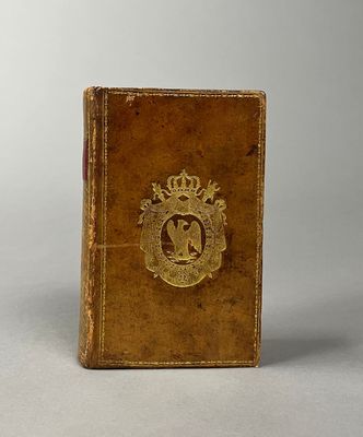 un vieux livre orné d'un emblème doré, posé sur une table