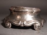 a silver bowl with a handle on a table