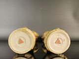 pair of porcelain figurines of a man and woman on a black surface