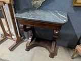 une petite table avec un plateau en marbre et un miroir accroché au mur