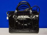 un sac à main noir posé sur une table blanche