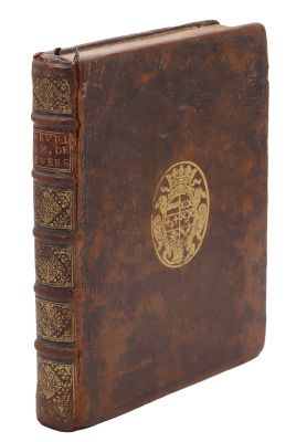 un vieux livre avec un emblème en or sur la couverture