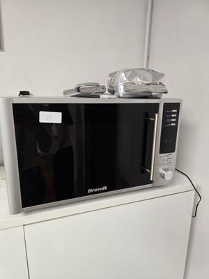 un micro-ondes posé sur un meuble de cuisine