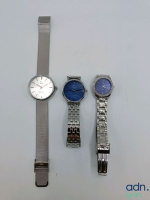 Trois montres sont posées les unes à côté des autres sur une table.