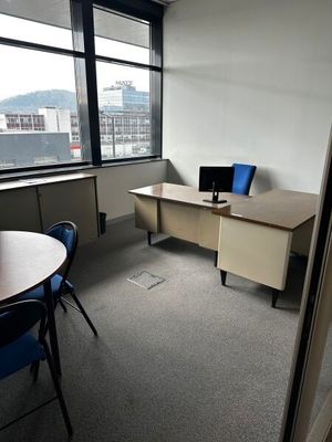 une pièce équipée d'un bureau, d'une chaise et d'un écran d'ordinateur