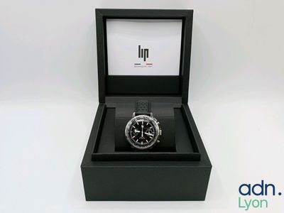 gros plan d'une montre dans une boîte sur une surface blanche