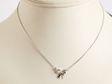 collier plaqué argent avec un pendentif en forme de nœud, présenté autour du cou d'un mannequin
