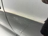 a man standing next to a car with a dirty door handle