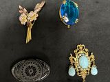 three pieces of jewelry on a black surface