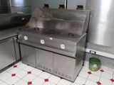 une cuisinière en acier inoxydable dans une cuisine au sol carrelé de rouge et de blanc