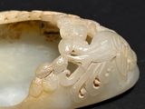 a white stone with a dragon on it on a black surface