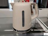 une bouilloire blanche posée sur une cuisinière
