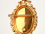 a picture of a gold brooch hanging on a clothes line