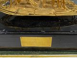 a gold sculpture of a boat on a black base