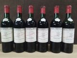 six bouteilles de vin sont alignées sur une table en bois