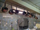 pots and pans hanging from the ceiling in a kitchen