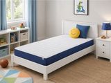 un lit blanc sur lequel sont posés un oreiller bleu et un oreiller en forme de smiley